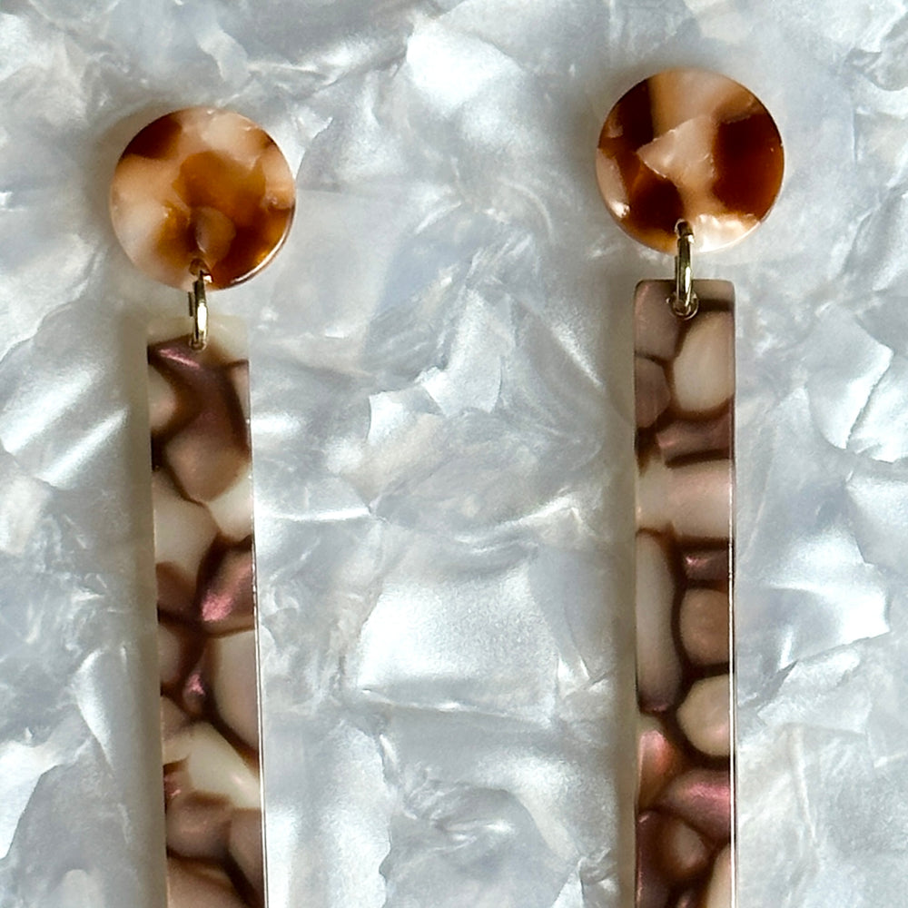 close up of acrylic Matchstick Drop Earrings in Eggplant Crackle purple and brown