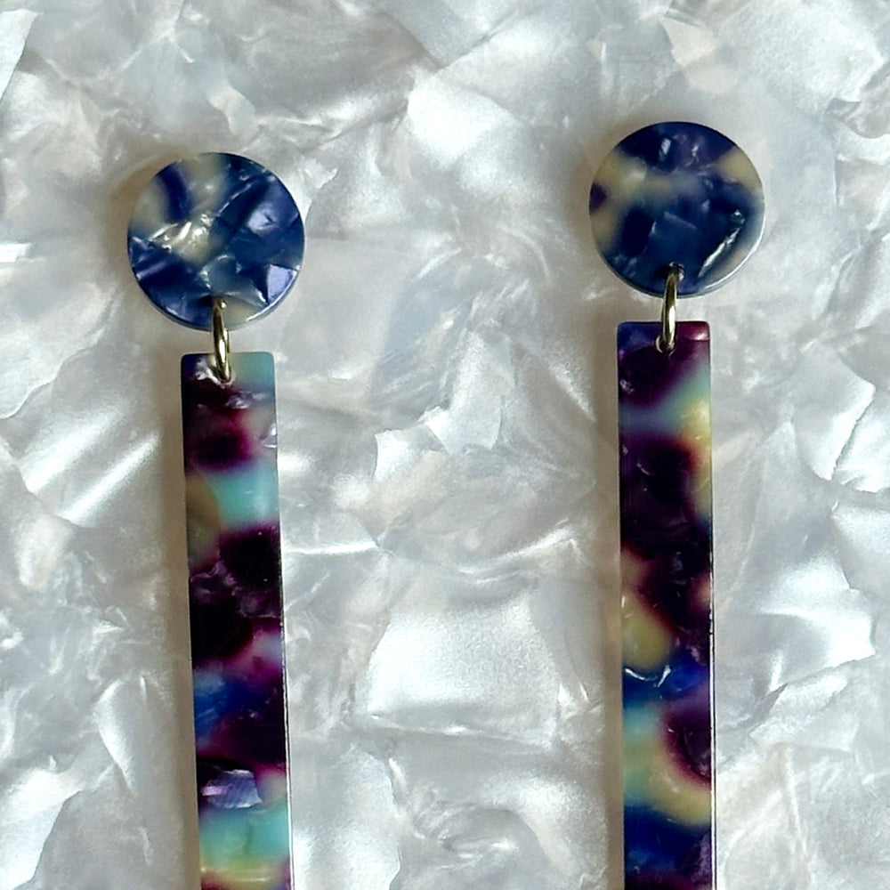 close up of acrylic Matchstick Drop Earrings in Reign Check blue and purple