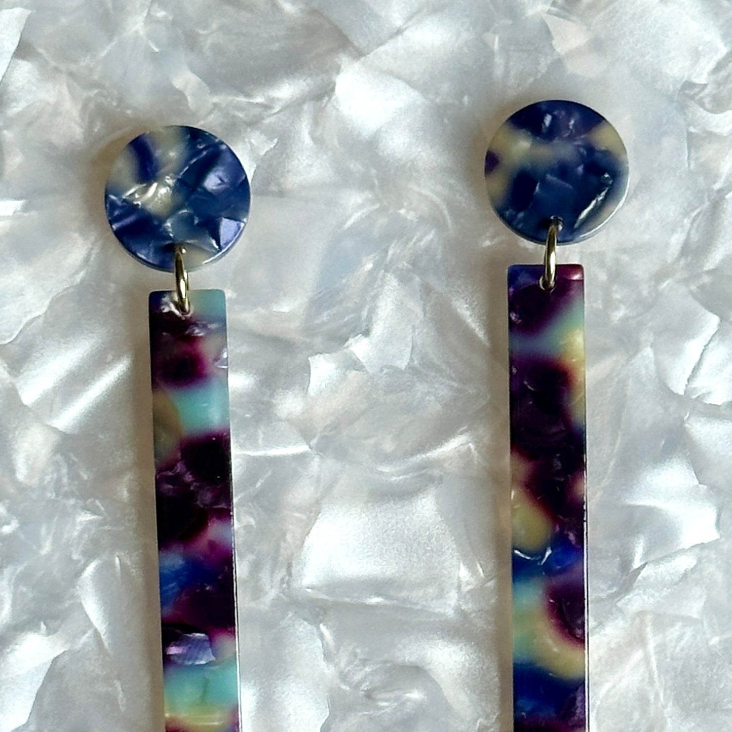 close up of acrylic Matchstick Drop Earrings in Reign Check blue and purple